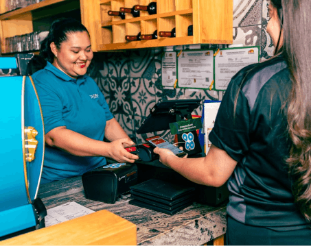 Cajera cobrando con el punto de venta en un restaurante