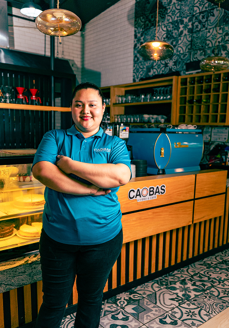 Encargada de una cafetería frente a la barra de su negocio
