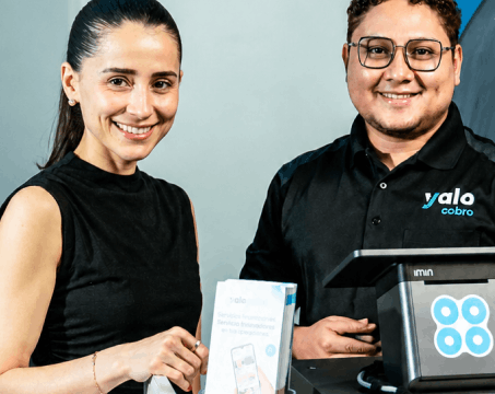Clienta y asesor de Yalo Cobro junto a una terminal de punto de venta